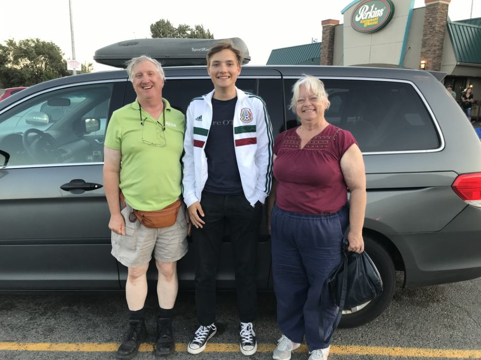 Gastfamilie auf dem Parkplatz vor dem Auto