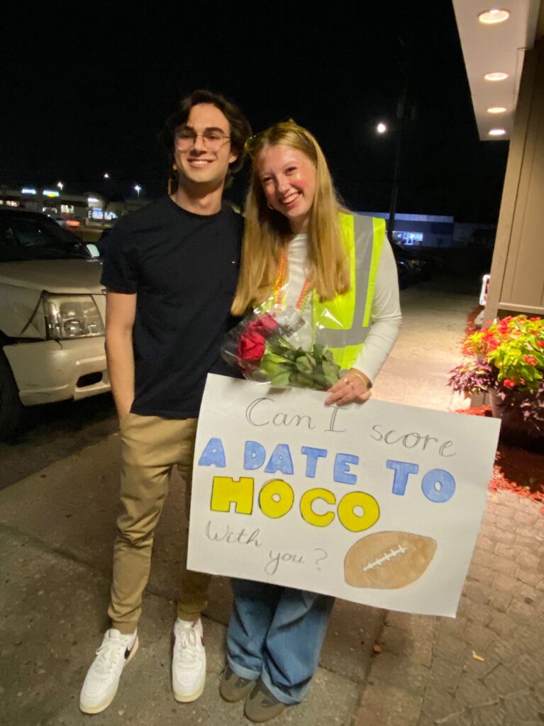 Zwei Jugendliche mit HOCO Schild