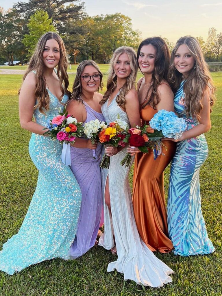 Freundinnen in Ballkleidern mit Blumen