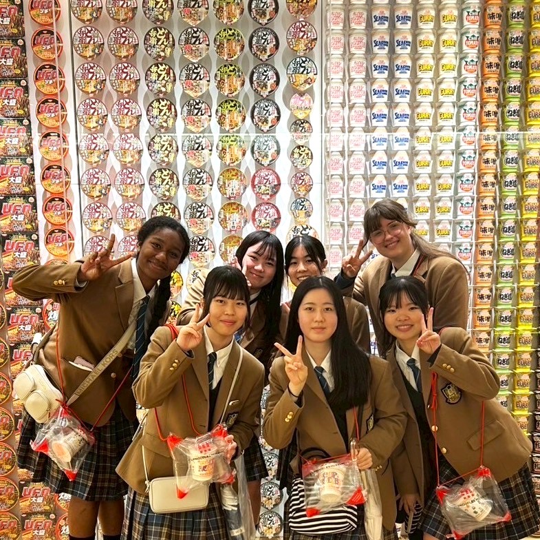 Freundinnen im Cup Noodle Museum vor einer Wand mit vielen Instand Nudel Bechern