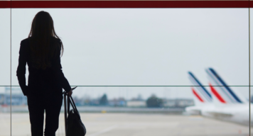 Junge Frau von hinten am Flughafen, Flugzeuge im Hintergrund