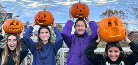 Halloween_Header vier Freundinnen mit geschnitzten Kürbissen