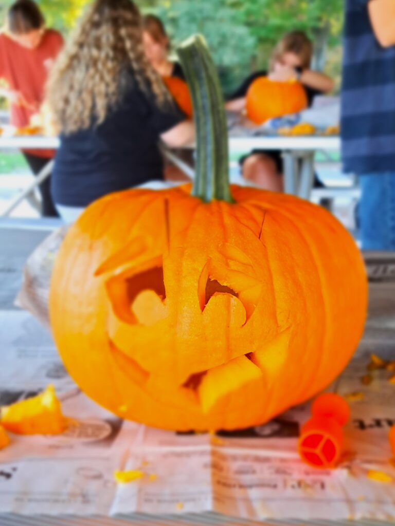 orangener Kürbis mit ausgeschnitzten Augen und Mund