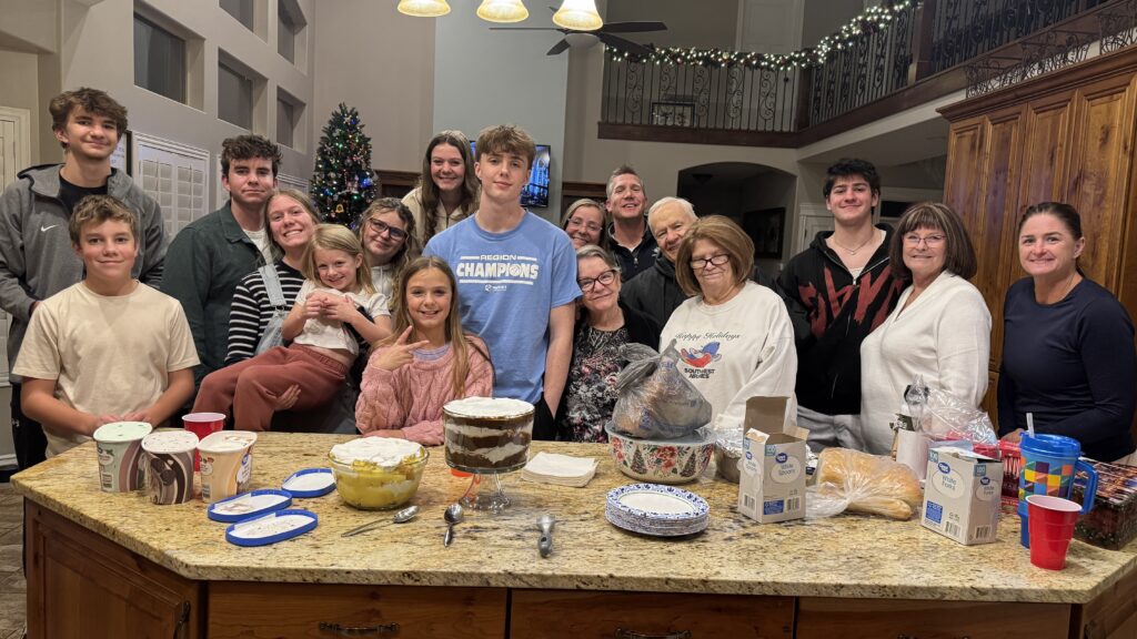 Gruppenbild einer großen Gastfamilie im weihnachtslichen Wohnzimmer