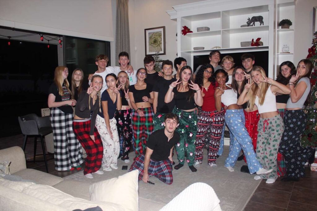 Gruppenbild mit Jugendlichen in Weihnachtsschlafanzügen in einem Wohnzimmer