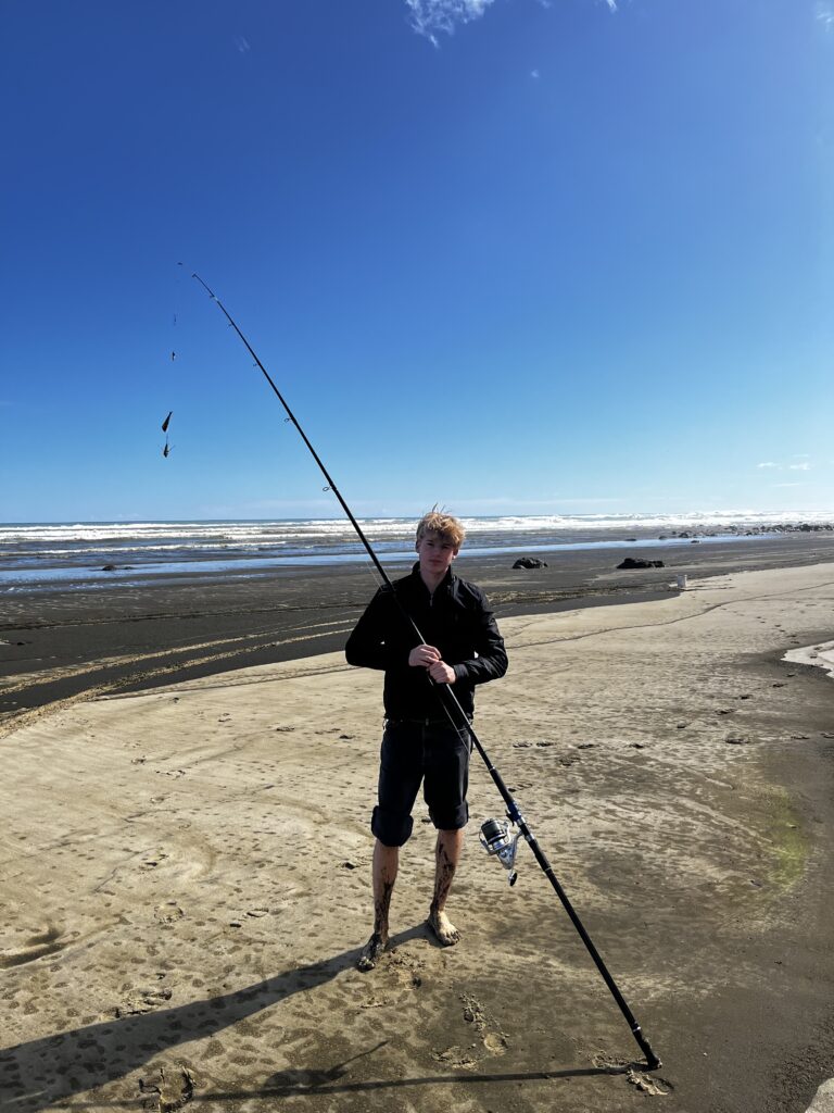 Fritz mit Angel am Strand von Neuseeland