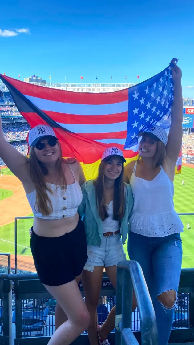 drei Freundinnen mit USA Flagge im Stadion
