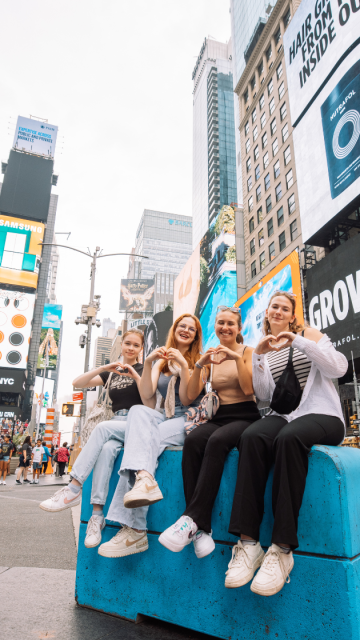 Au pairs zeigen Herzen am Times Square