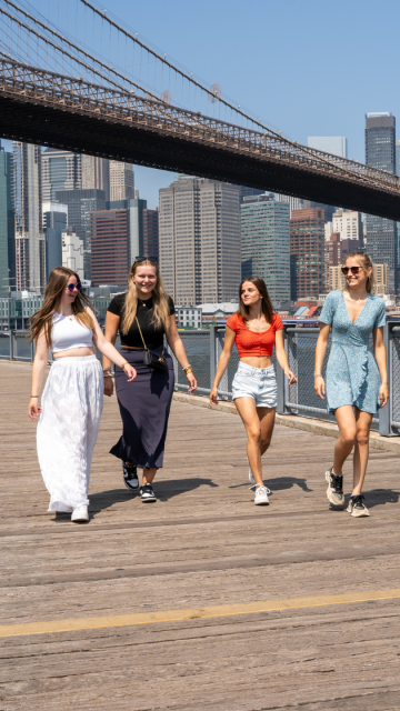 Au pairs spazieren auf der Promenade mit Manhattan im Hintergrund