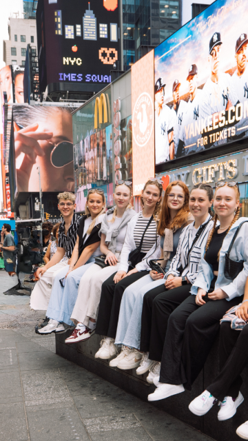 Gruppen von Au pairs sitzen am Times Square