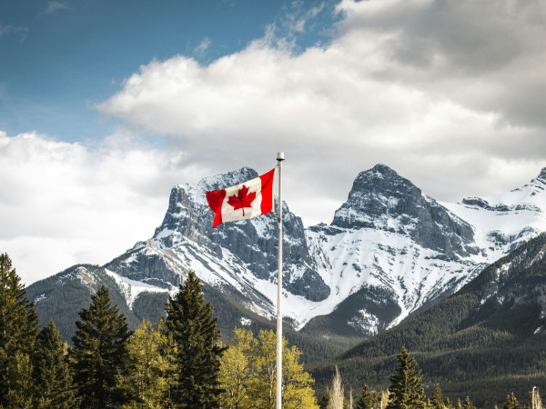 Berge mit Schnee und wehender Kanada Flagge