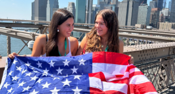 Zwei Schülerinnen auf Brookyln Bridge mit Manhatten Skyline im Hintergrund