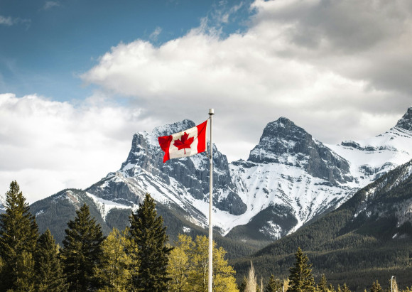 Berge mit Schnee und wehender Kanada Flagge